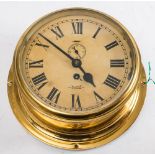 A Sestrel circular brass bulkhead clock: the dial with Roman numerals and subsidiary seconds dial