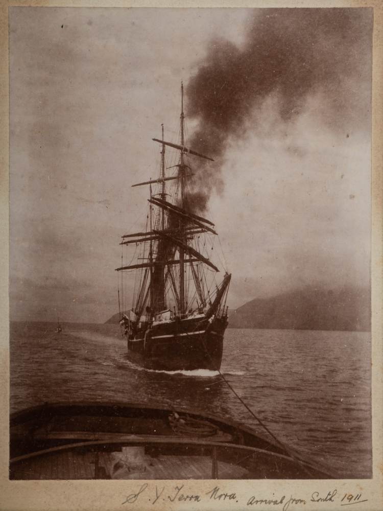 A mounted photograph of RYS Terra Nova under tow inscribed to border 'SY Terra Nova arrival from