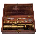 A 19th century lacquered brass microscope by H Comyns, Chelsea,