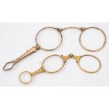 A pair or yellow metal lorgnettes with scroll chased decoration: and a pair of gold plated
