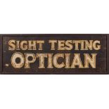 An early 20th century oak sign 'Sight Testing Optician': the text cut from an oak base and