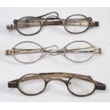 Three pairs of 19th century silver spectacles with folding arms.