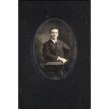 A black and white oval half-length studio portrait photograph of F E Davies: signed 'Frank' in blue