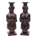 A pair of carved wooden figure head style candle stands:,