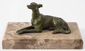 A bronze figure of a recumbent greyhound: unsigned, mounted on a marble plinth base 15cm long.