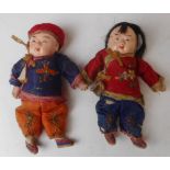 A pair of Chinese dolls: with moulded composition heads , wearing traditional costume,