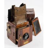 A mahogany and brass Ensign Popular reflex 'Tropical Model' three quarter plate camera: fitted