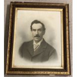 A large framed and glazed photographic portrait of a moustached gentleman.