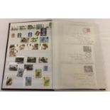 A large brown album containing 400 British unused stamps and 8 first day covers.