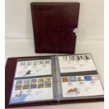 A burgundy Royal Mail First Day Covers binder containing 55 covers mainly from 2001-2004.