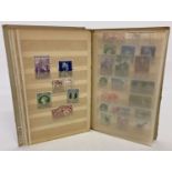 A small vintage album containing antique and vintage postage stamps, mostly unused.