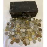 A black metal cash tin containing vintage British and foreign coins.