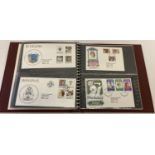A burgundy binder containing a quantity of Diana, Princess of Wales first day covers.