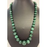 A graduating malachite bead necklace with screw barrel clasp.