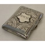 An antique silver cigarette case with floral decoration throughout and initialled cartouche.