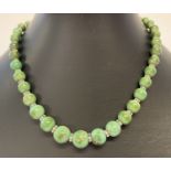 A graduating green turquoise bead necklace with 9ct gold spring clasp.