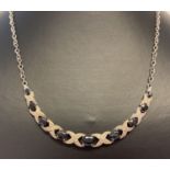 A silver Hugs and Kisses style sapphire and diamond fixed pendant necklace.