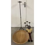 A large round open basket together with 2 wrought iron candle sticks and a wooden jointed figurine.