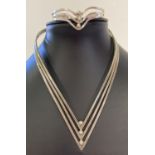 A modern design silver torque style necklace with matching bracelet.