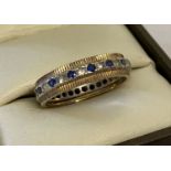 A vintage 9ct gold full eternity ring set with small blue sapphires and clear stones.