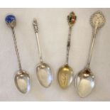 4 vintage silver spoons with decorative handles.