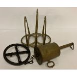 A vintage brass roaster with circular hanging wheel complete with hooks.