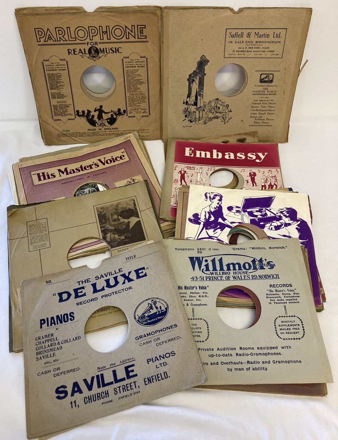 A collection of 60+ vintage paper and cardboard 78 record sleeves to include advertising.