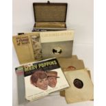 A vintage record carry case containing a collection of 78 records.