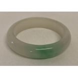 A chunky Chinese jade bangle with flat interior and rounded exterior.