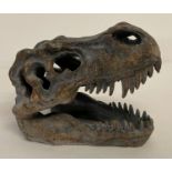 A small modern ornamental T-Rex skull ornament with fixings for wall hanging.