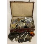 A small vintage suitcase containing an assortment of misc. items.