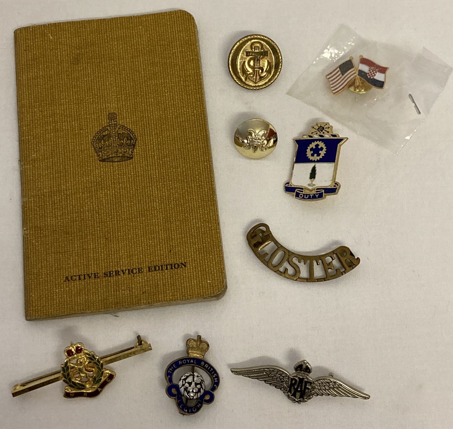 A small collection of assorted military badges, buttons & items.