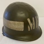 A WWII style US Military Police M1 helmet with swivel bale, front seam and painted markings.