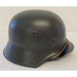 A reproduction re-enactors German WWII M42 steel helmet with leather straps and liner.
