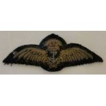 A vintage Royal Navy pilot qualification cloth wings badge with silver coloured metal anchor.