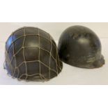 A WWII style US M1 helmet with Capac liner and string cam net.
