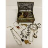 A casket style jewellery tin containing a collection of vintage and modern jewellery.