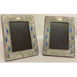 A pair of silver fronted Art Nouveau style picture frames with blue and green enamelled detail.
