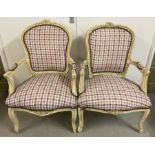 A pair of wooden framed Louis XV style low armchairs, painted cream.