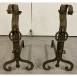 A pair of vintage metal fire dogs with shaped tops and feet, and ring detail to fronts.