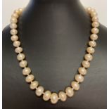 A 17" string of larger sized peach freshwater pearls, with magnetic clasp.