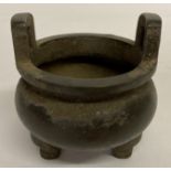 A Chinese metal 2 handled, 3 footed censer with signature marks to underside.