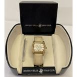A boxed ladies Beverley Hills Polo Club wristwatch with square shaped face and cream leather strap.
