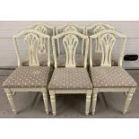 A set of 6 white painted shabby chic dining chairs with turned legs and decorative panel backs.