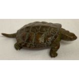 A small bronze figure of a turtle.