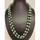 A 46" beaded necklace of alternate Chinese green jade and freshwater pearls.