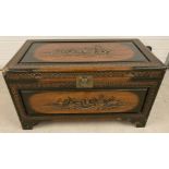 An Oriental camphor wood trunk with highly carved detail and brass catch.