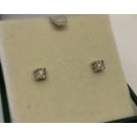 A pair of 9ct white gold diamond set stud earrings. Each earring set with 0.05 ct round cut diamond.