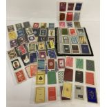 A folder containing a collection of vintage single playing cards with backs featuring advertising.