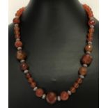 An 18" carnelian beaded necklace with white metal T bar clasp.